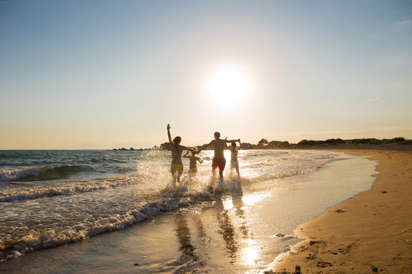 Famiglia che gioca tra le onde al tramonto sulla spiaggia di Vasto, Abruzzo